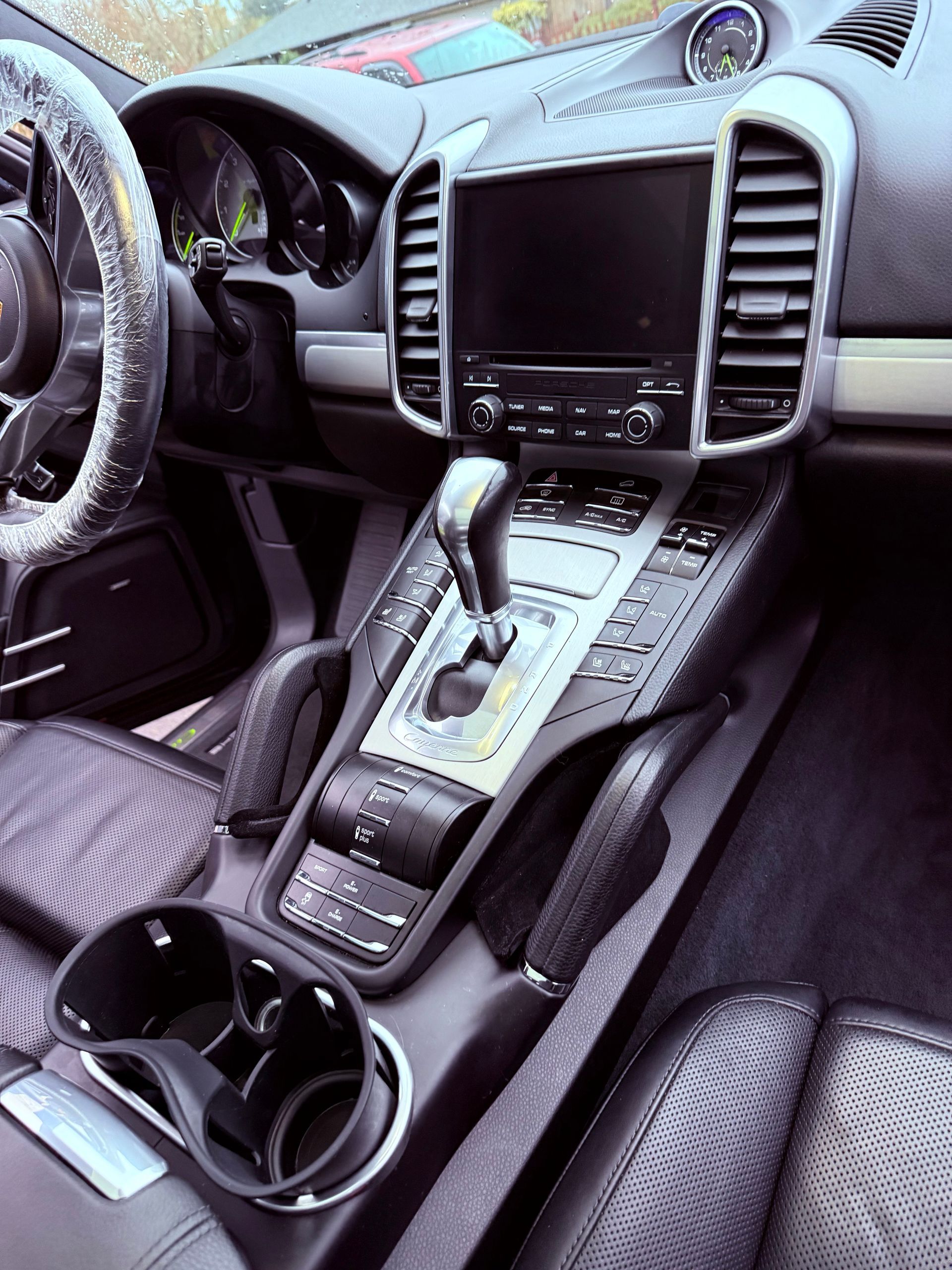Luxury car interior with black leather seats, center touchscreen, and steering wheel