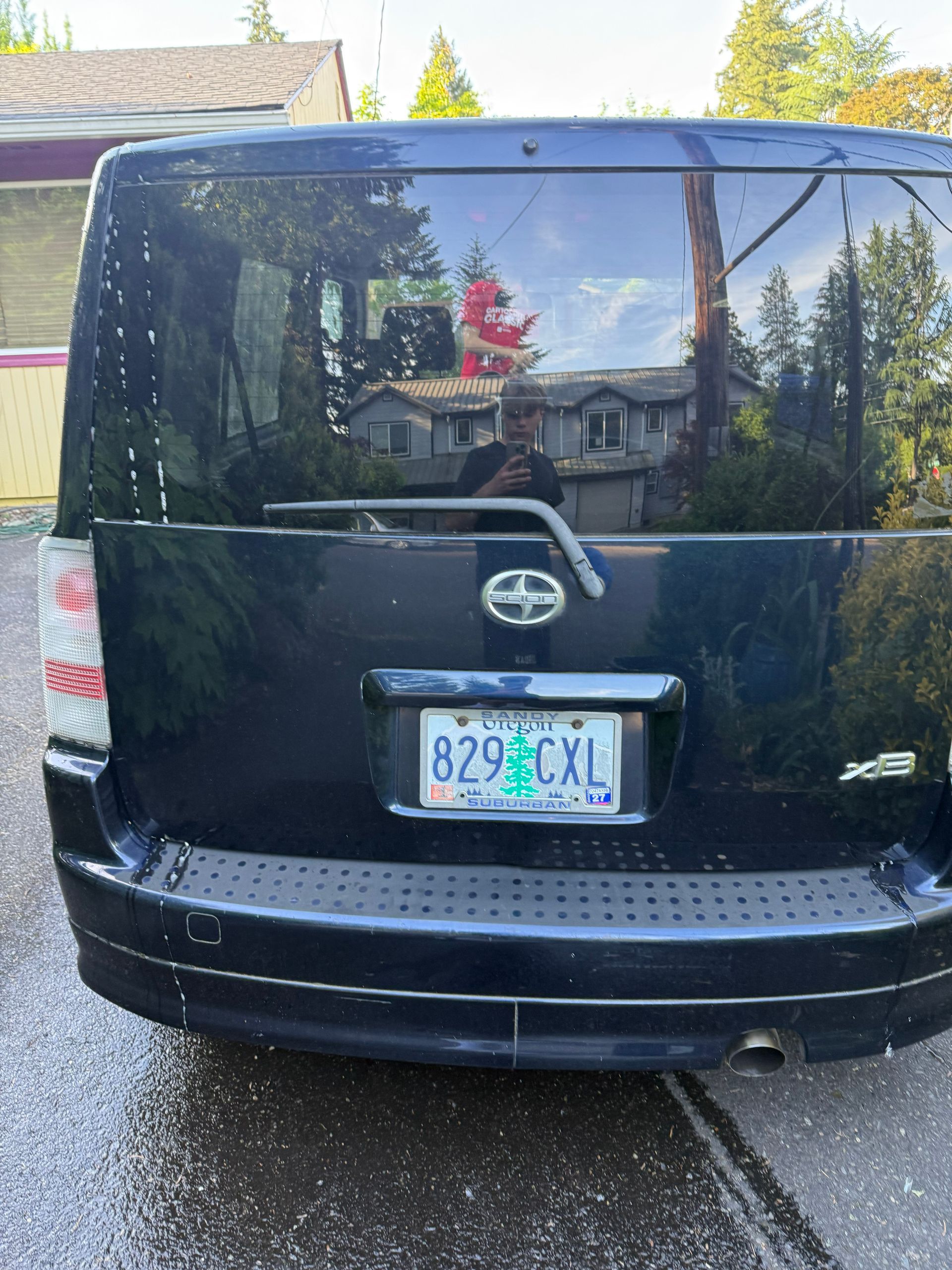 Rear view of a black Toyota minivan parked on a residential street.