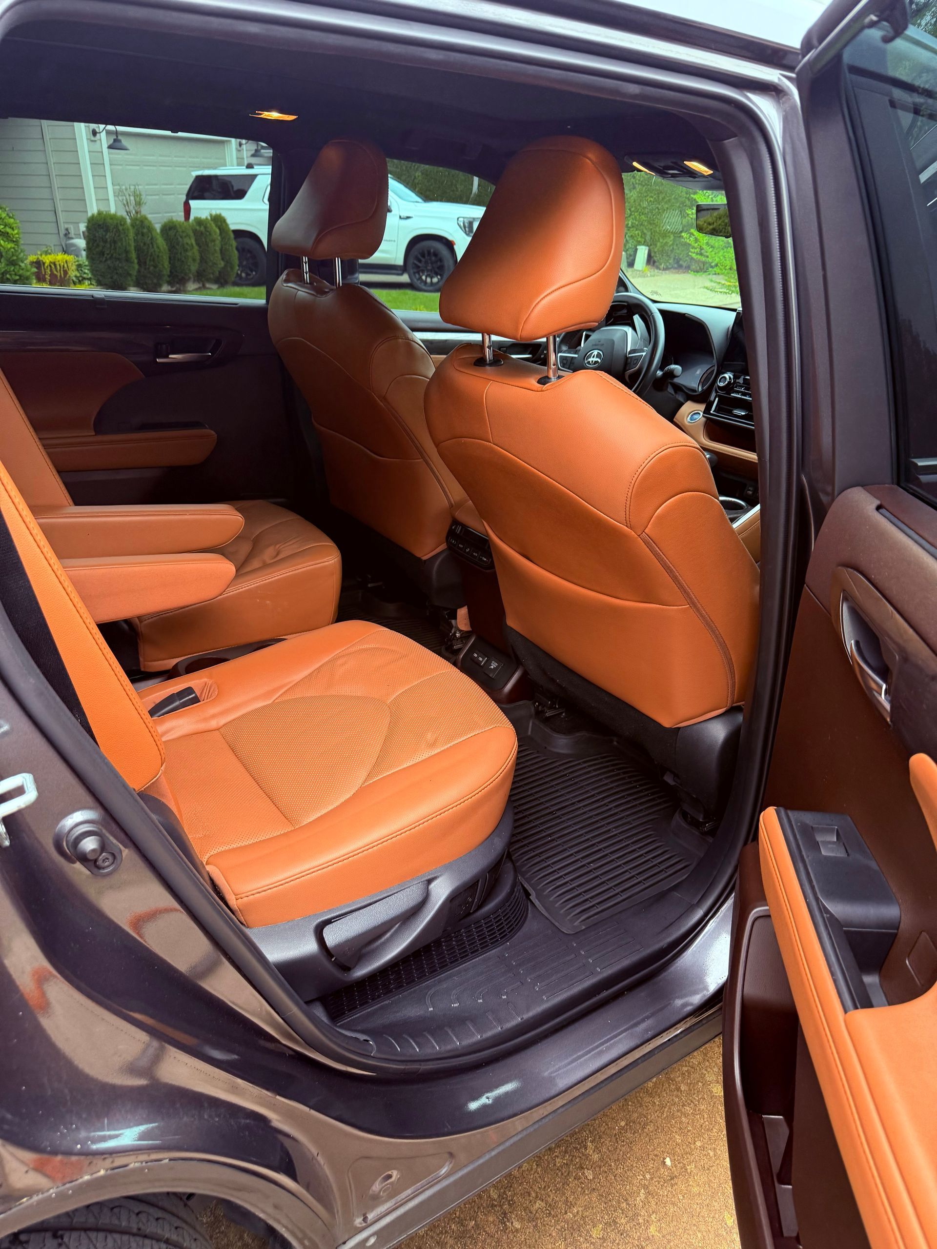 Orange car seats and door panels inside a black vehicle with the rear door open.