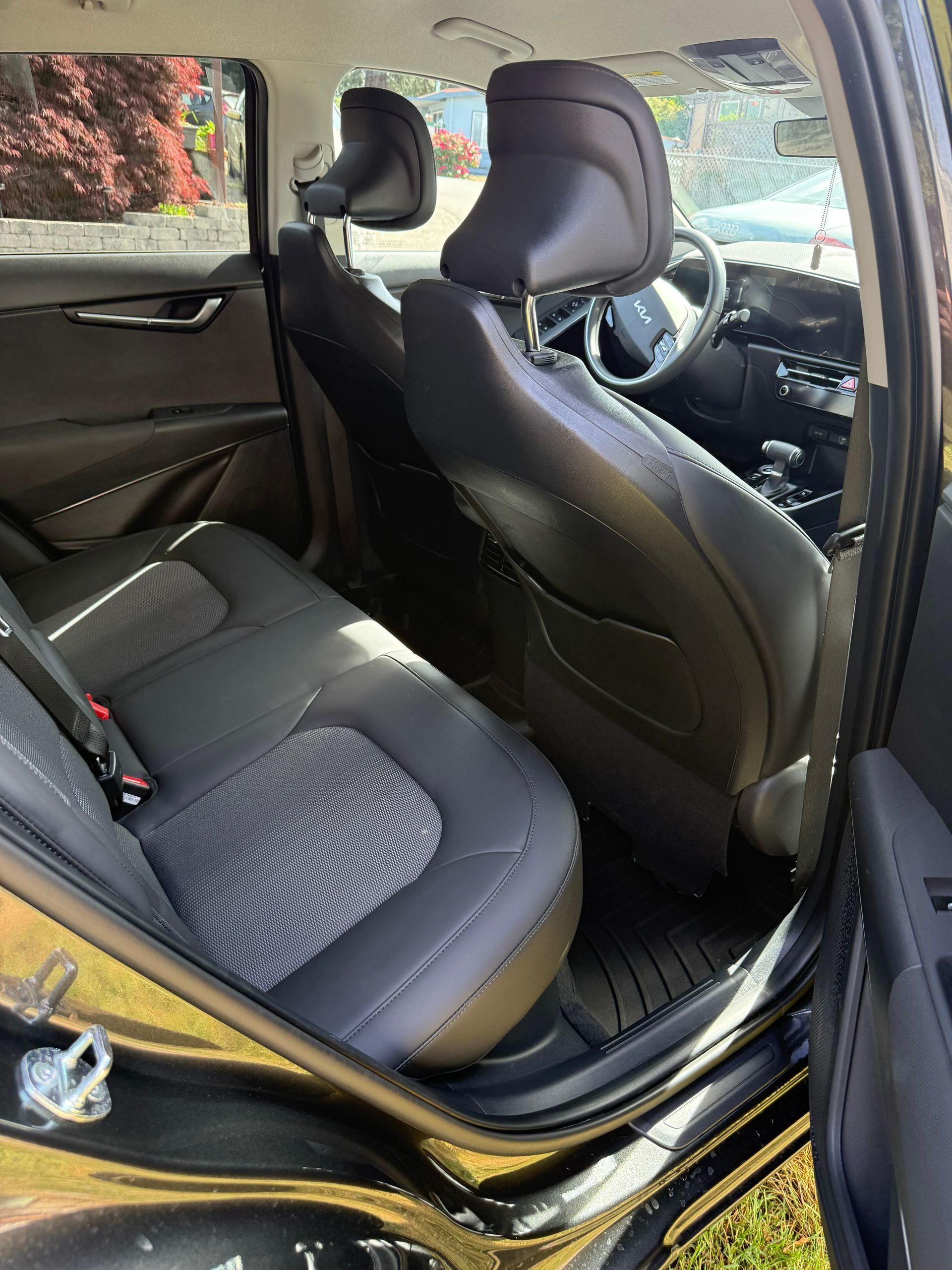Car interior with black seats viewed from the open rear door