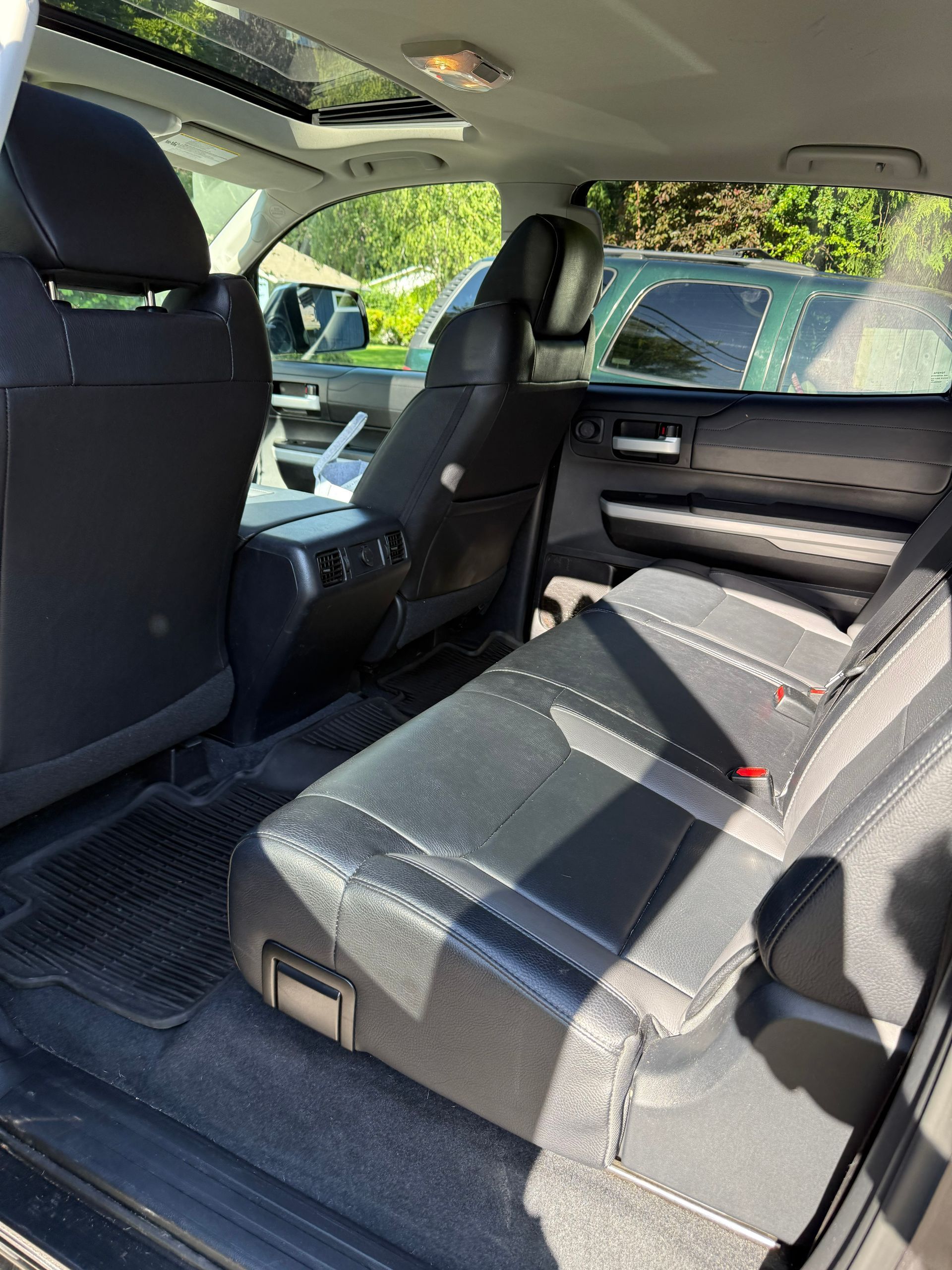 Car interior with folded rear seat and black upholstery in sunlight