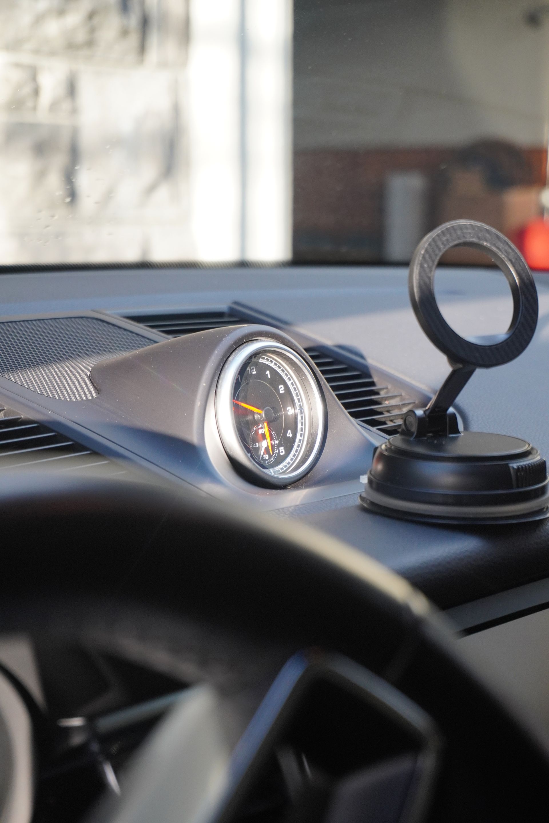 Car dashboard with a mounted GPS device and an analog gauge on the dash