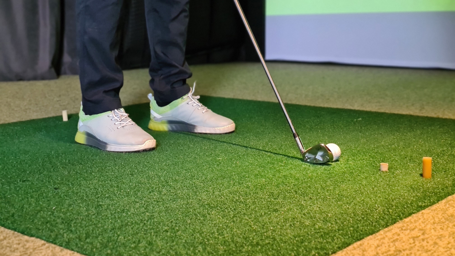 Golf balls scattered beside a ball basket and club on green turf