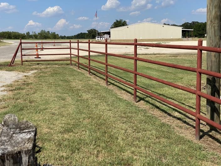 Pipe fence corner post and wire fence line.