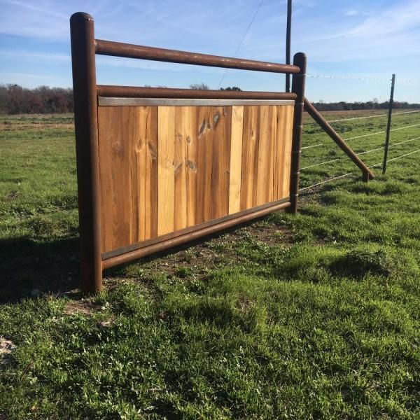 Long stretch of ranch fencing across grassy field.