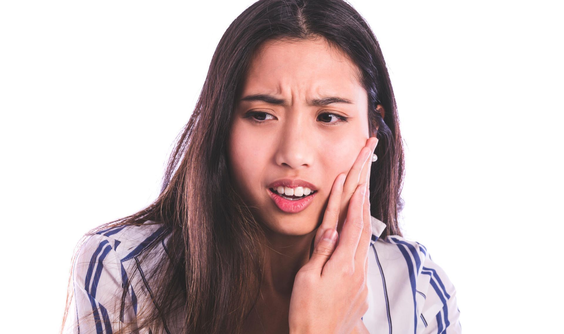 Woman holding her cheek with a pained expression, suggesting tooth pain