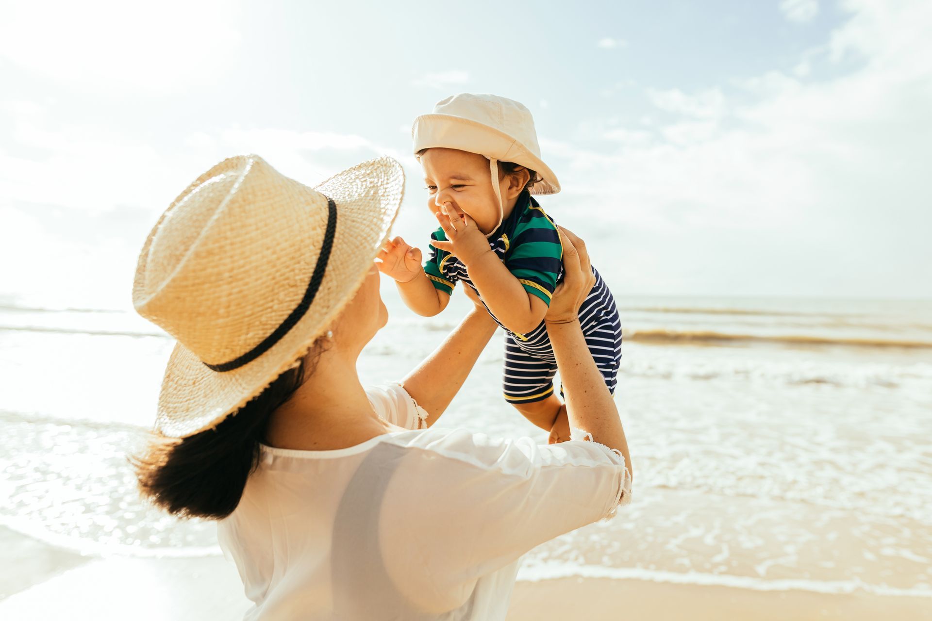 Mom holding a baby on a beach