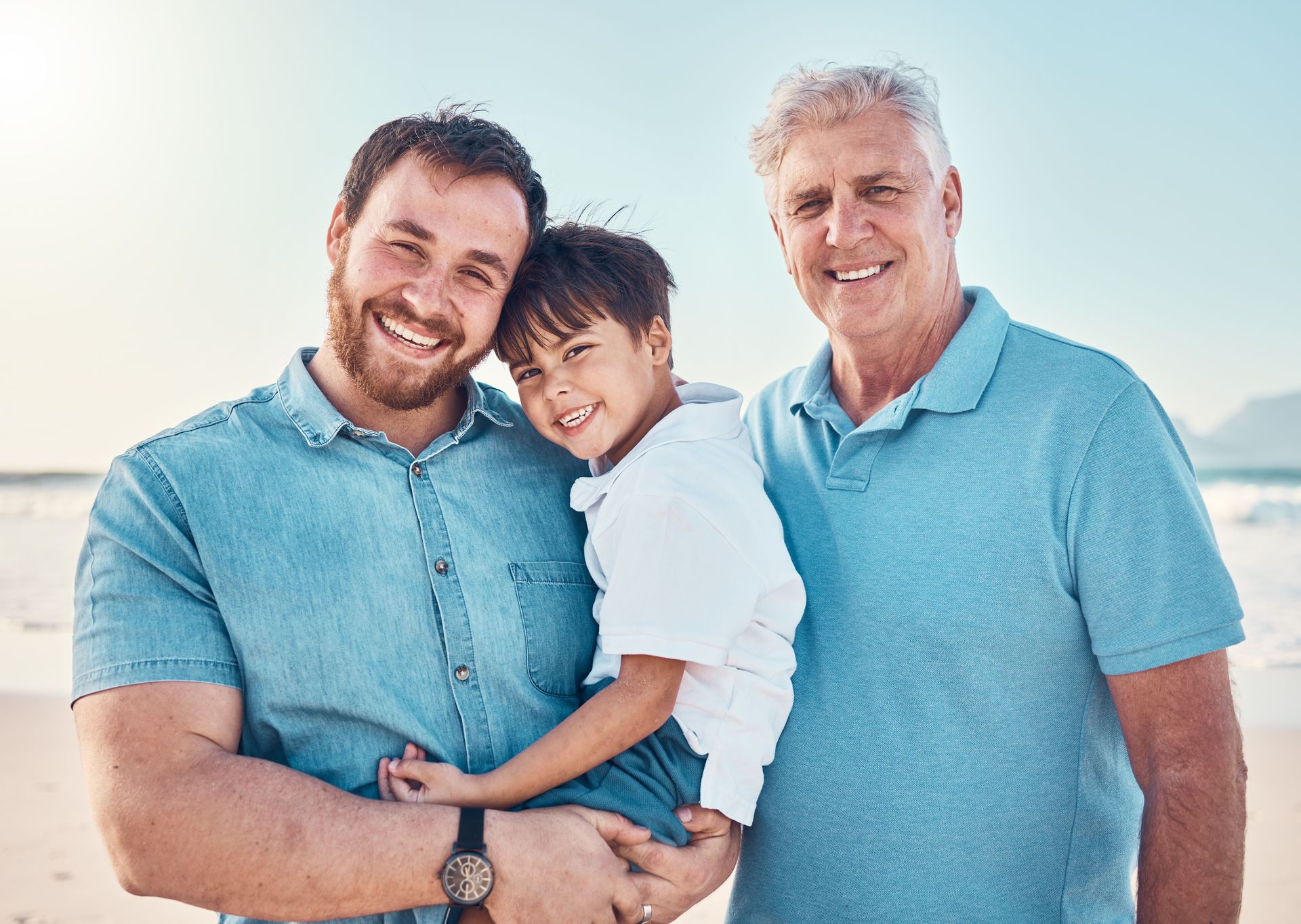 Two men and a child on a beach