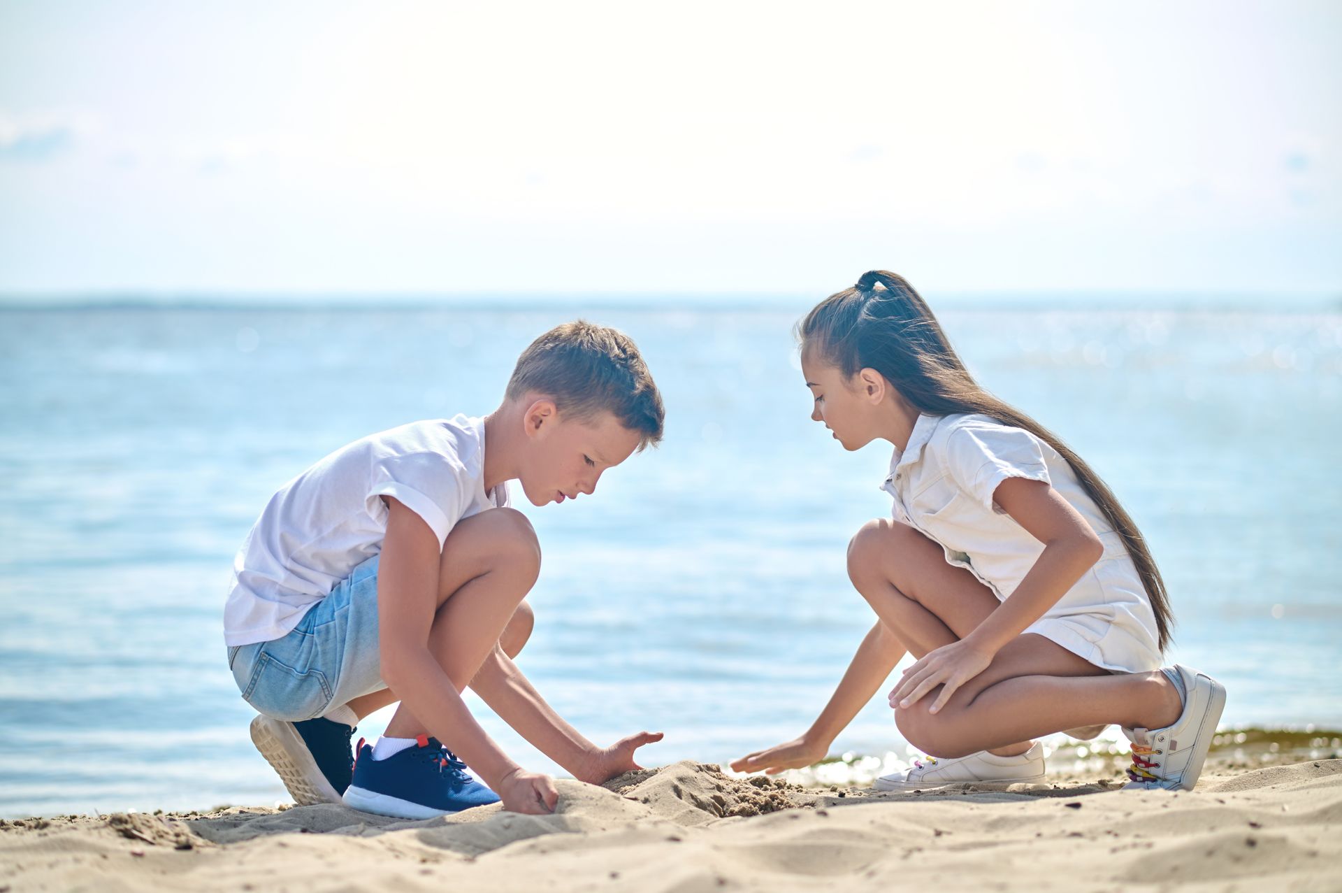 Two children playing in the sand on a beach