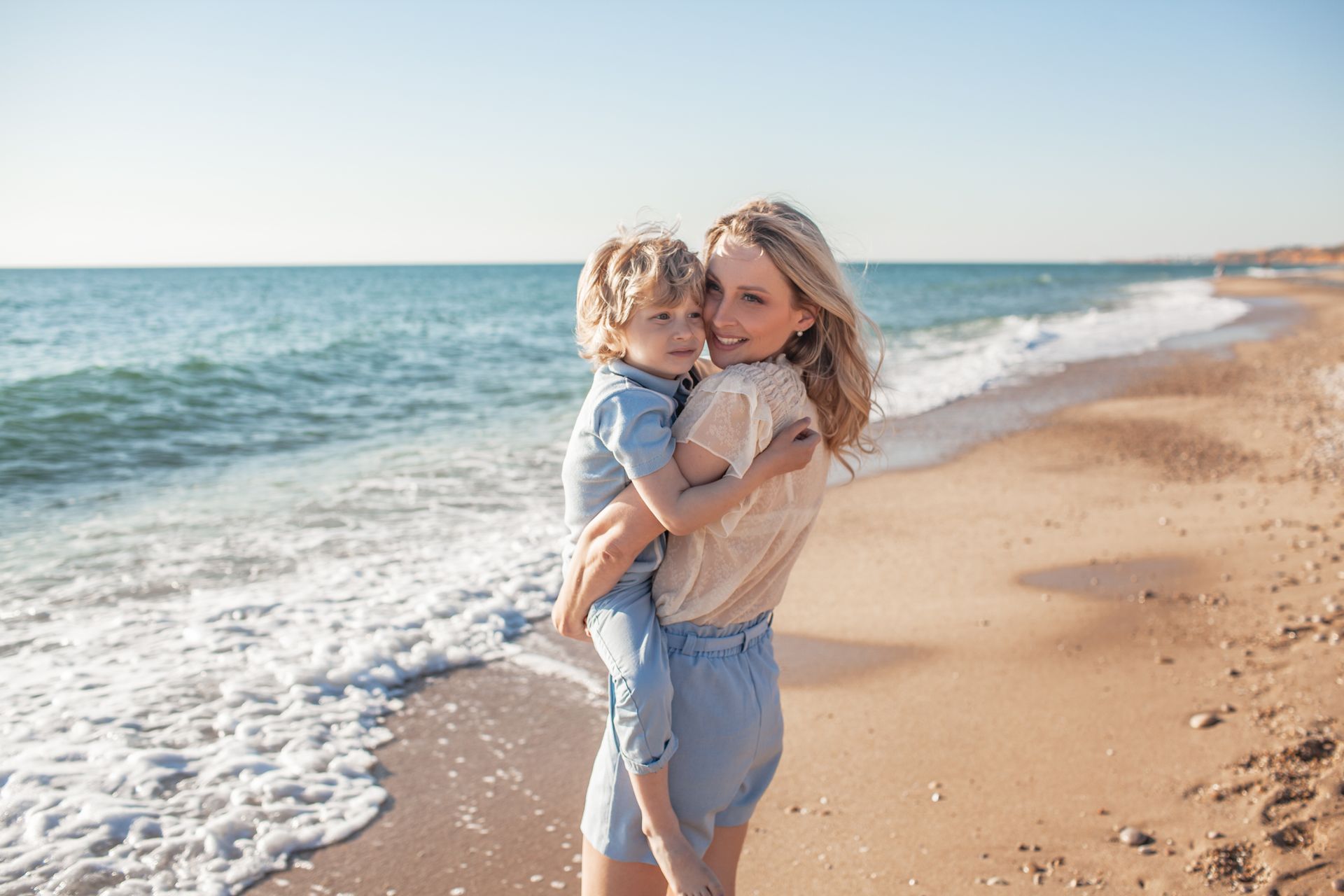 Woman holding a child on a beach
