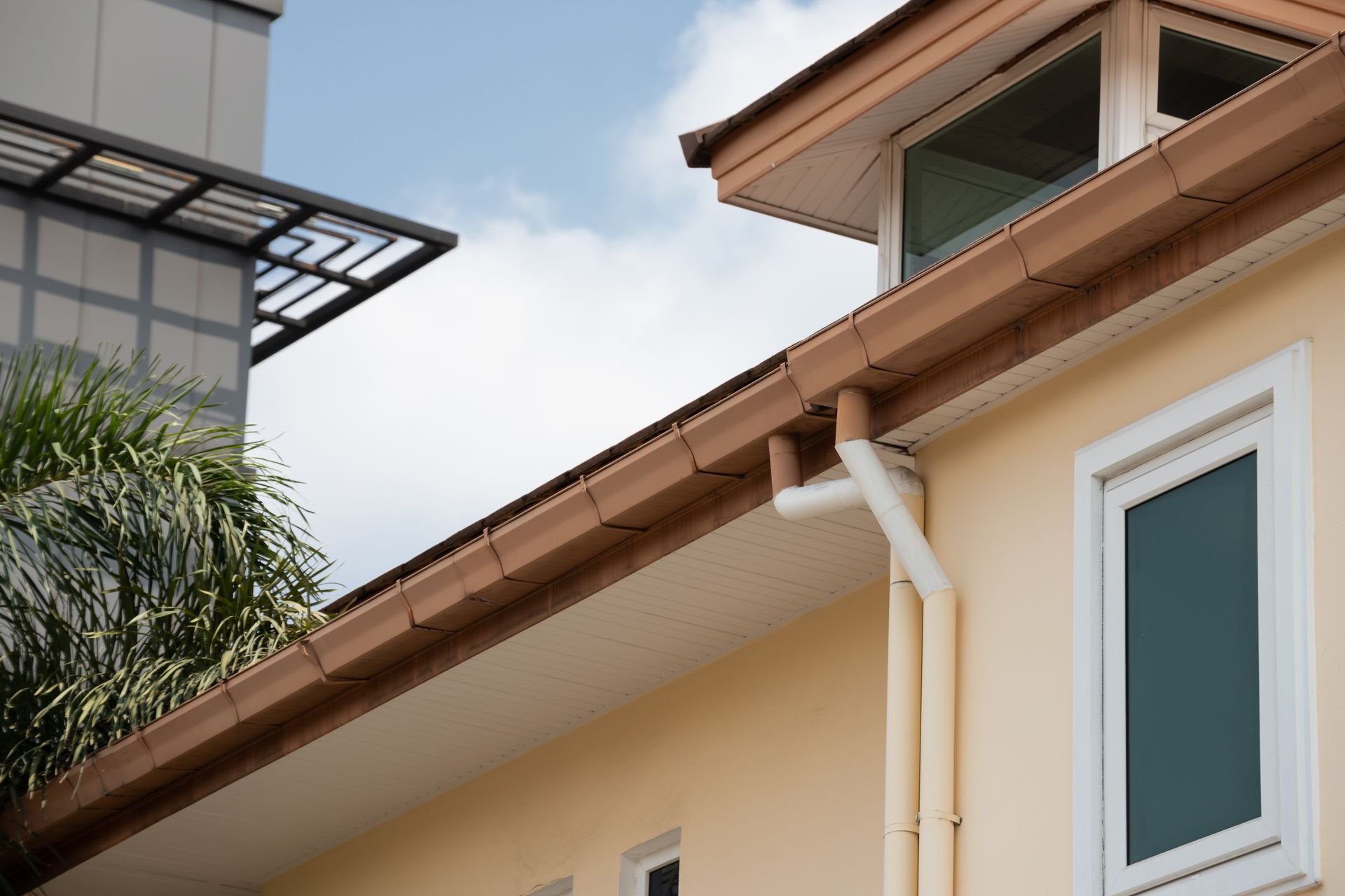 A house with a gutter on the side of it and a window.
