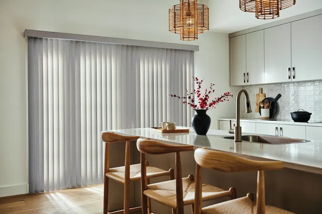 A living room with a chair and blinds on the windows.