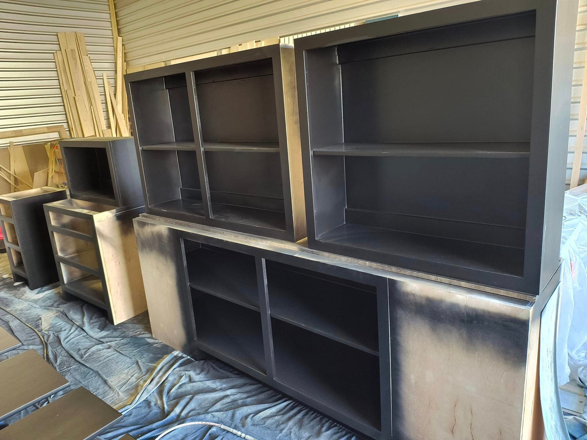 A row of black shelves sitting on top of each other in a room.