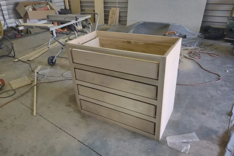 A wooden dresser is being built in a workshop
