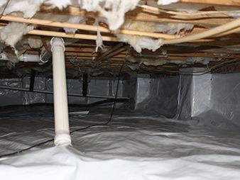 Crawl space with plastic vapor barrier, exposed beams, ductwork, and a white support pipe.