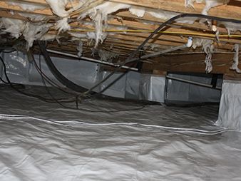 Insulated crawl space with exposed joists, hanging wires, and a vapor barrier on the floor