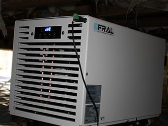 White FRAL industrial unit with front vents and a small digital display on top, indoors.