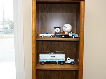 Wooden shelf with model trucks and a baseball on display