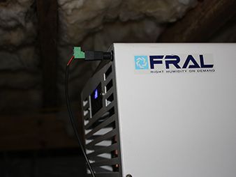 FRAL sign on a white machine in a rocky cave, with a small green sensor attached nearby