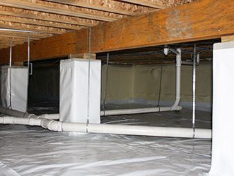 Crawlspace with exposed beams, ductwork, and white vapor barrier on the floor