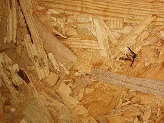 Close-up of textured plywood with wood chips and grain patterns in tan and brown tones
