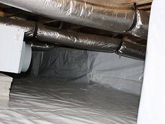 Insulated ducts in a crawlspace with a plastic vapor barrier on the floor