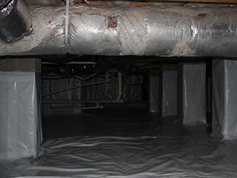 Low crawlspace with plastic-covered floor and silver insulated ductwork overhead