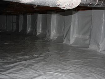 Plastic-lined crawlspace interior with a low ceiling and gray floor covering