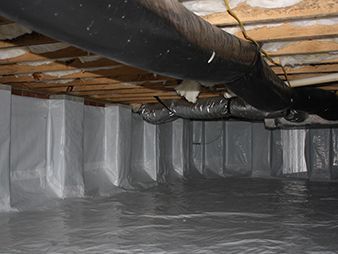 Crawlspace with a black insulated pipe overhead and a plastic-lined floor and walls