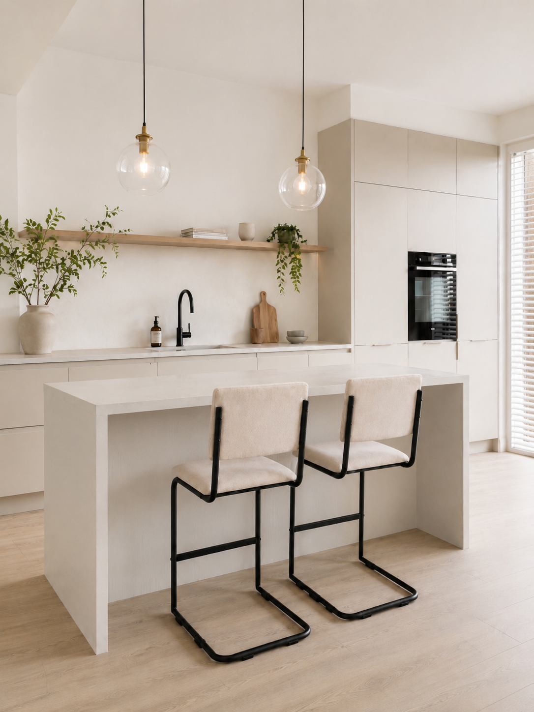 Twee beige gestoffeerde barkrukken met zwarte metalen frames op een houten vloer tegen een witte muur.