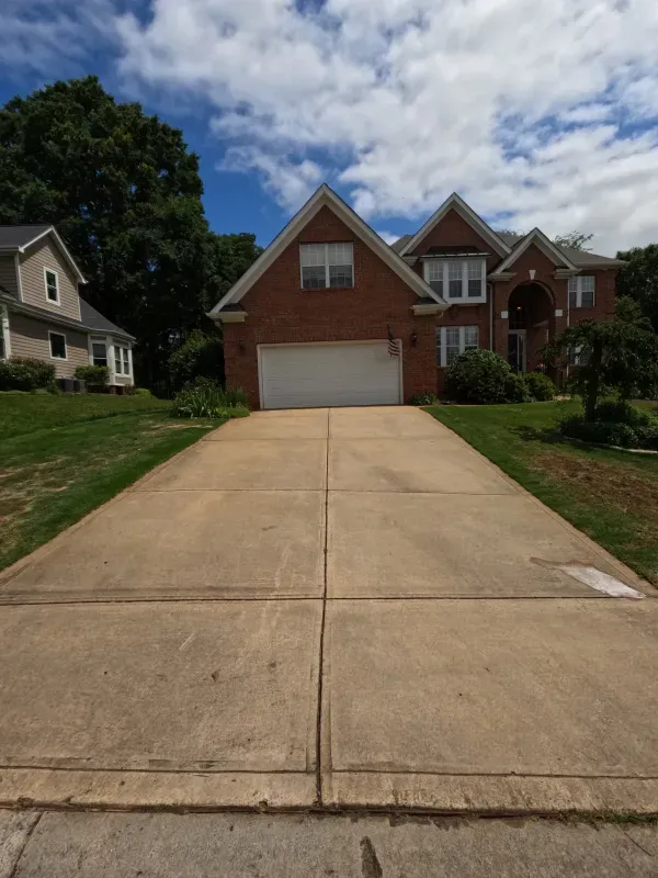 A driveway leading to a large brick house
