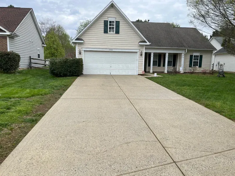 A driveway leading to a house with a white garage door