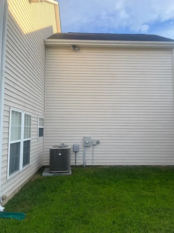 A house with a lot of windows and a lawn in front of it.