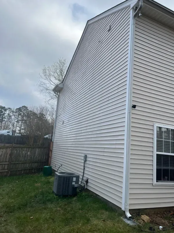 The side of a house with a window and an air conditioner.