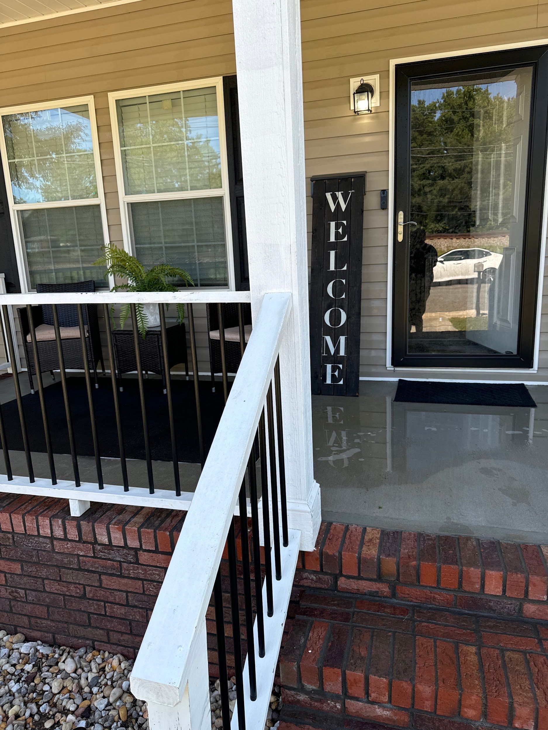 There is a welcome sign on the porch of a house.