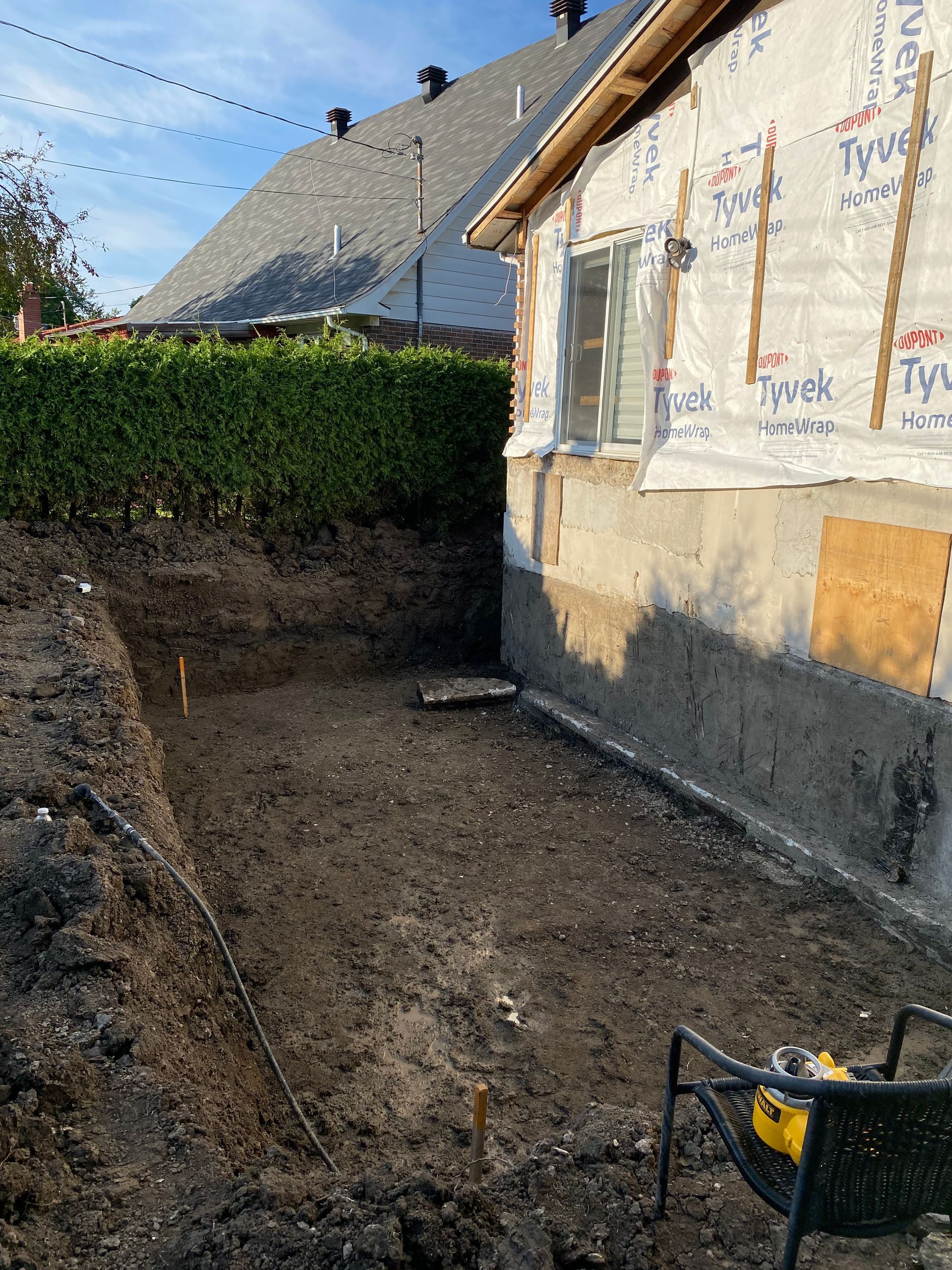 Un grand trou dans le sol devant une maison.