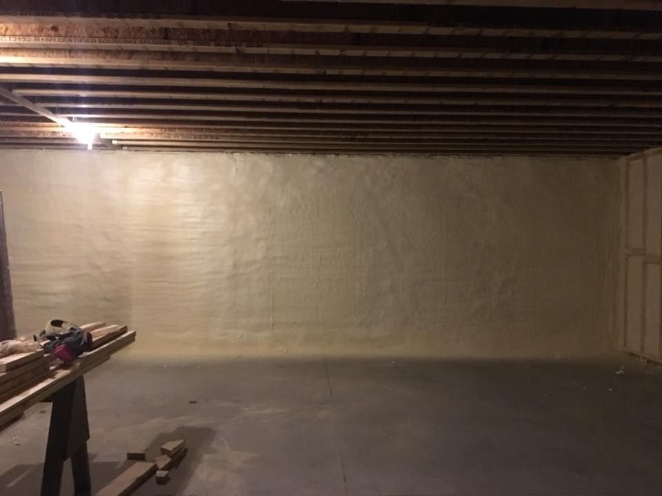 Empty unfinished basement with exposed ceiling joists and a bare concrete floor