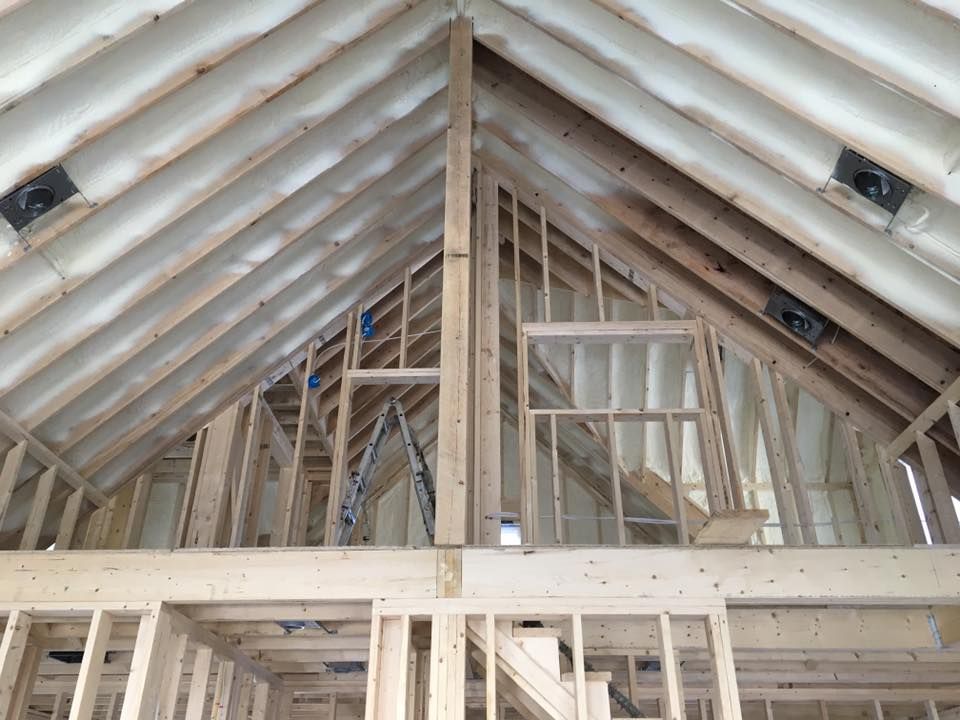 Unfinished attic with exposed wooden roof trusses and framing under construction