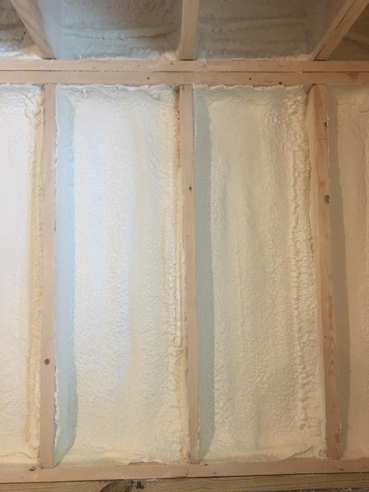 White foam insulation panels framed by light wood studs, with a vent or duct visible at the top left.
