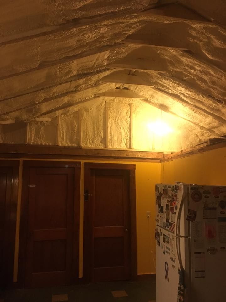 Yellow-lit kitchen with reflective ceiling insulation and cabinets below a bright overhead light