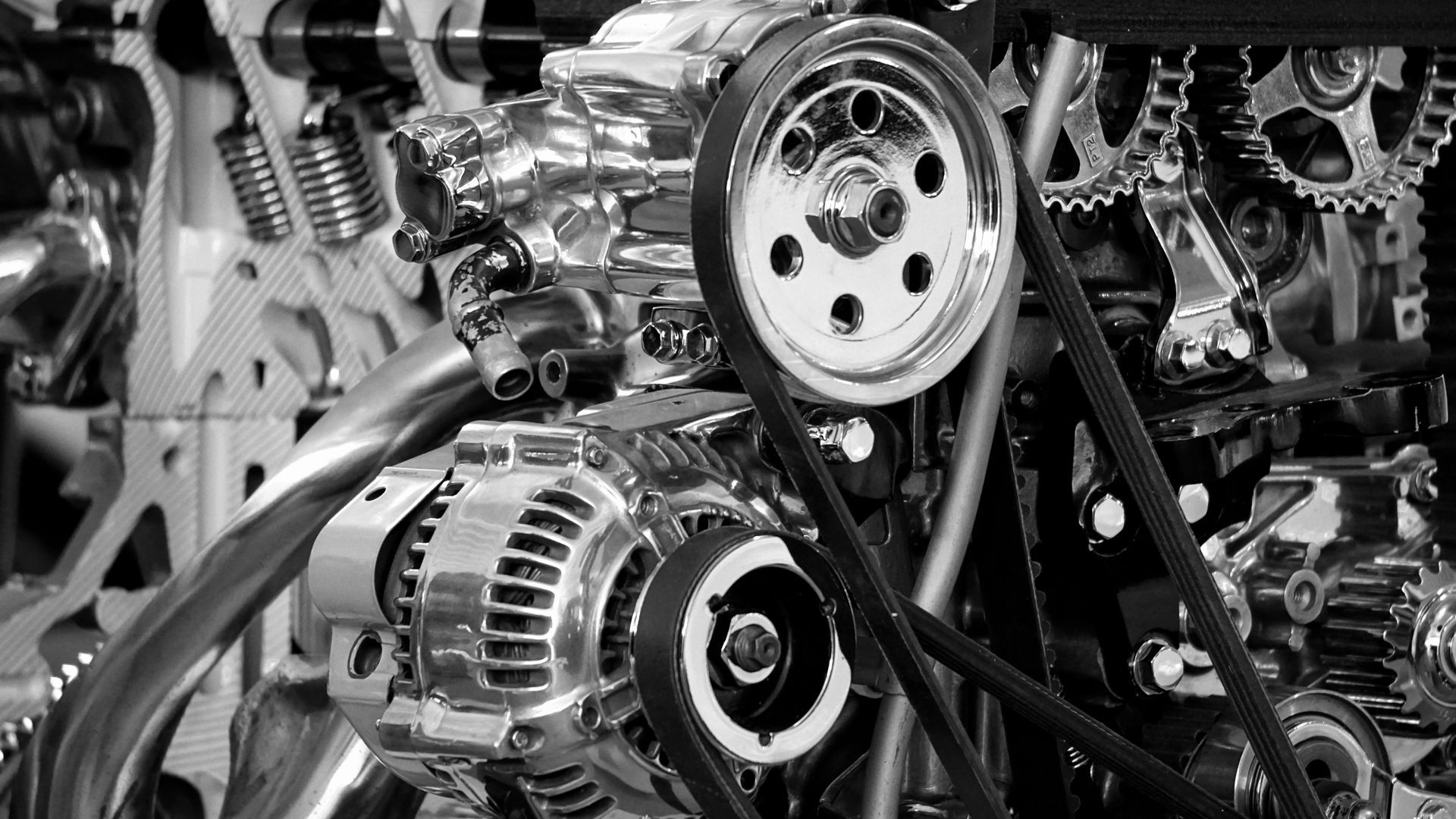Shiny chrome engine with belts, pulleys, and gears.
