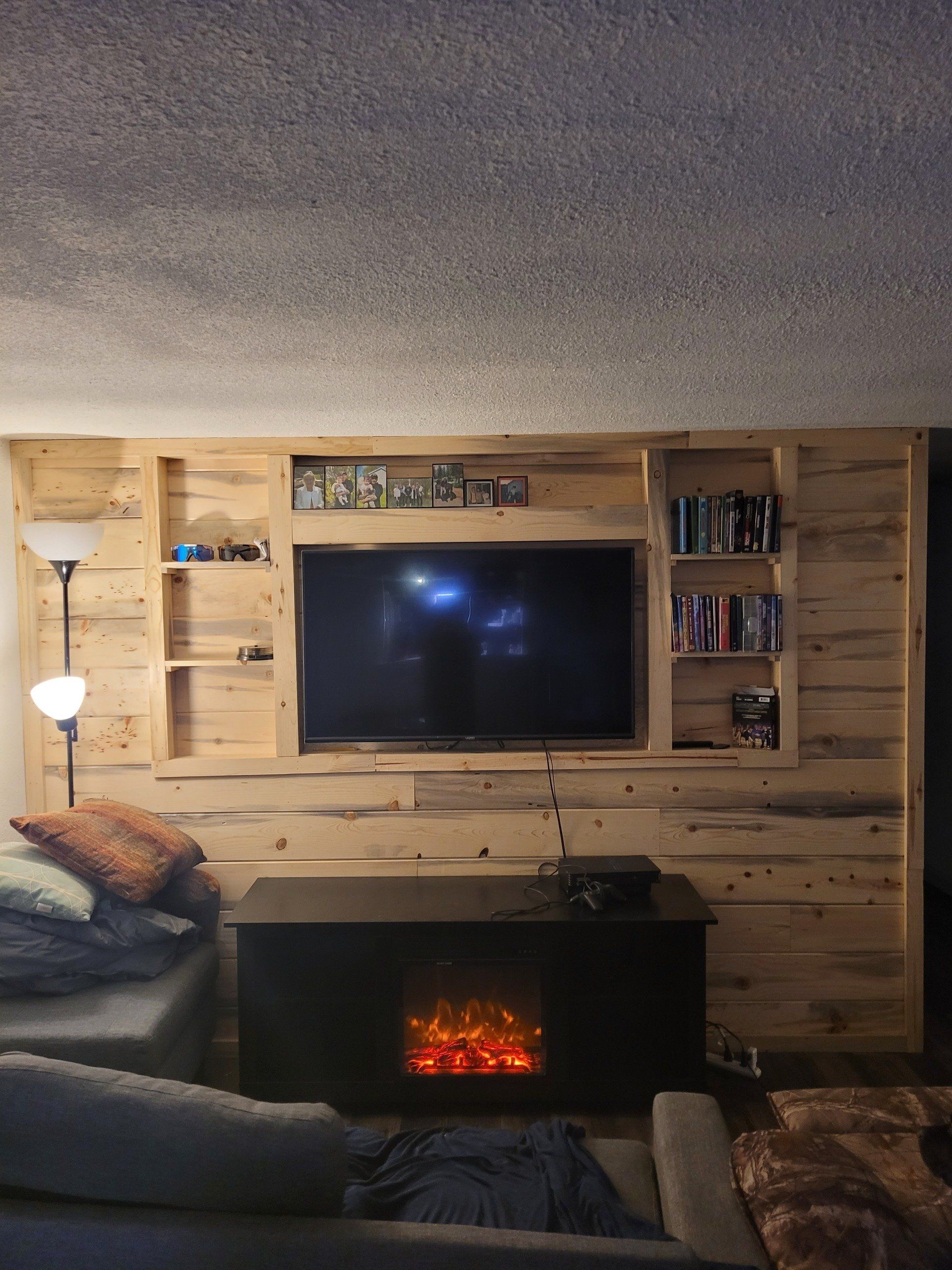 Wood-paneled wall with a built-in shelf and a window ledge holding potted plants.