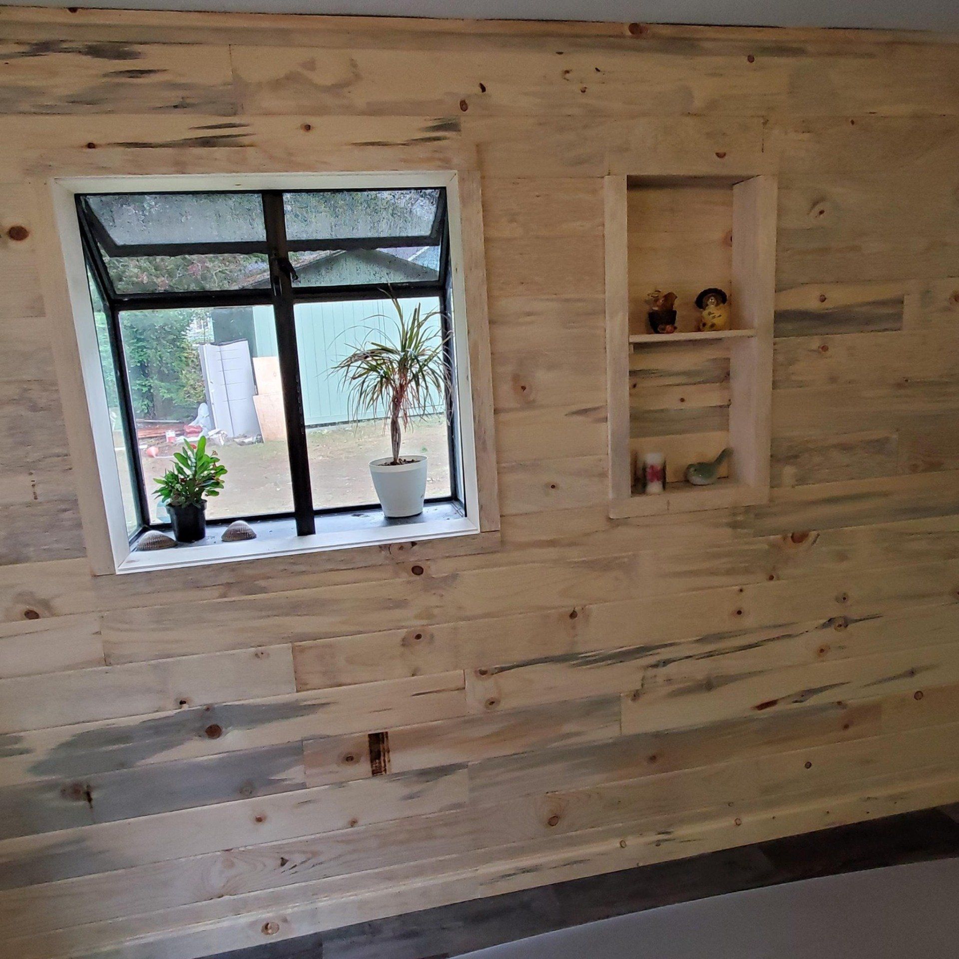 New wood paneling decorates the wall and completes the window frame and built-in shelving.