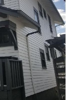 Gutters run along the eaves of a black and white two-story home.