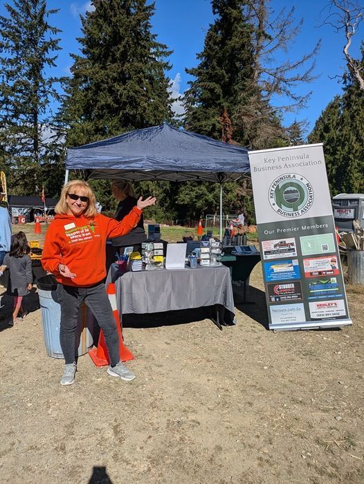 Photo of Kathy Wright standing in front of outdoor booth display.