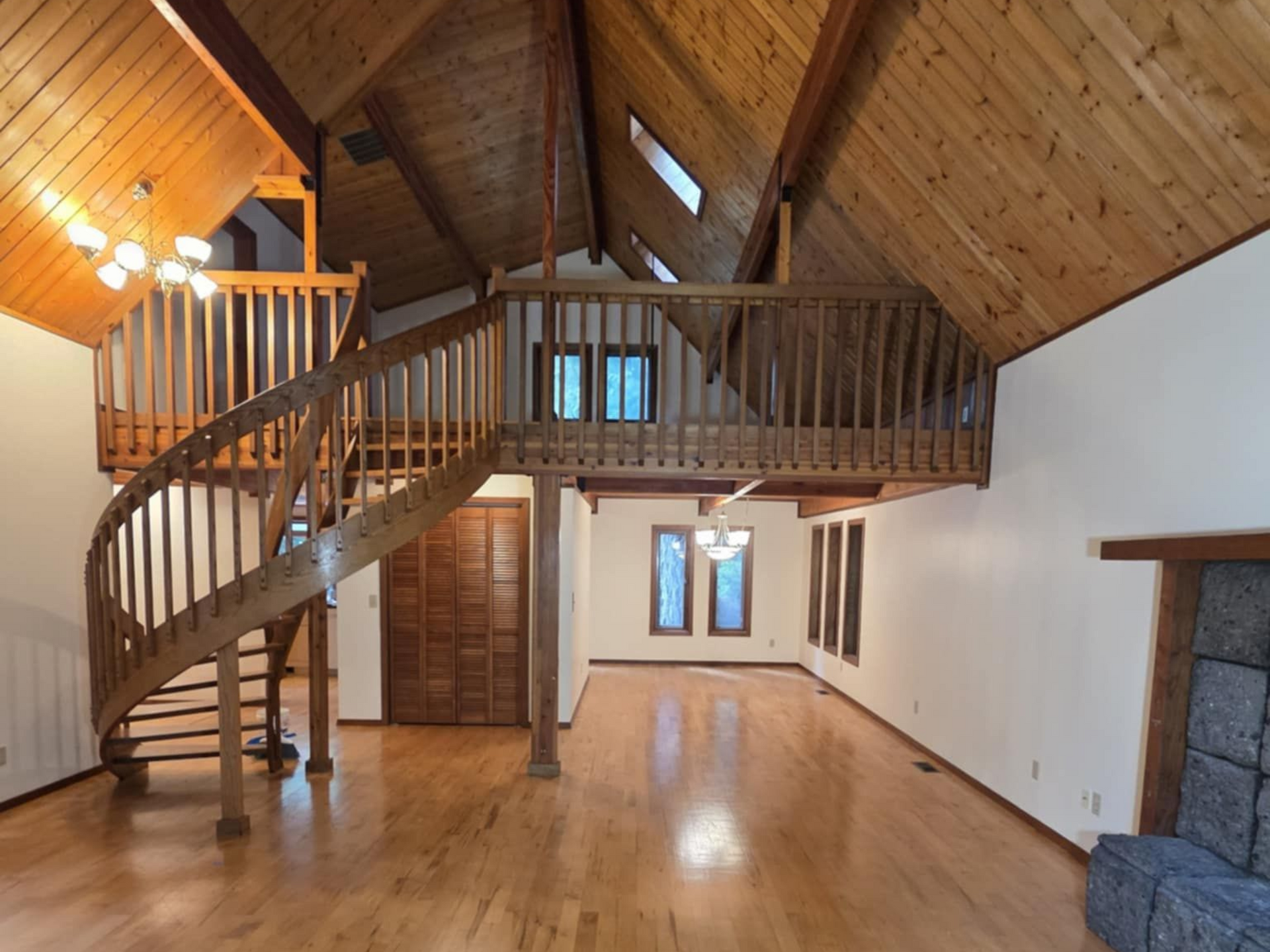 A freshly-painted cream interior complement the wooden floors. ceiling, trim, and winding staircase.  