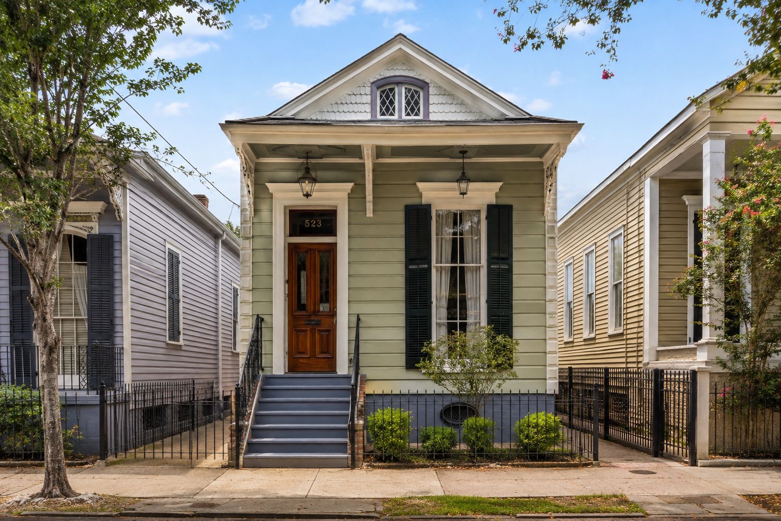 Colorful historic row houses with ornate balconies and shutters on a sunny street