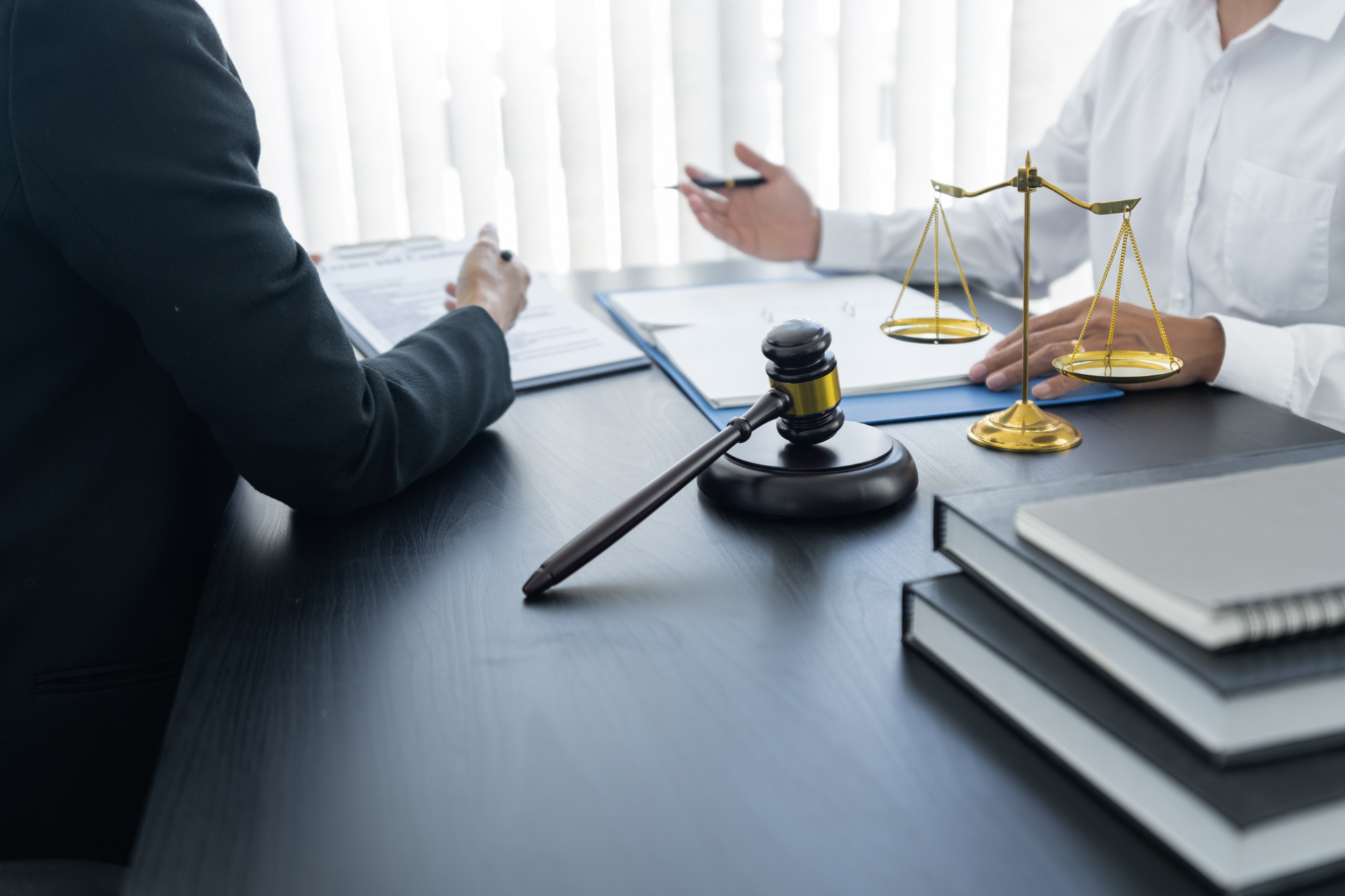 Lawyer meeting at desk with gavel, scales of justice, and stacked legal books