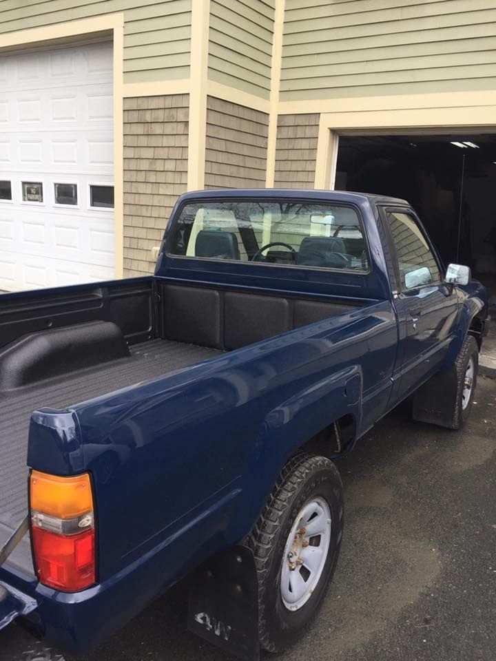 Side view of a blue truck with a srpay-on bedliner