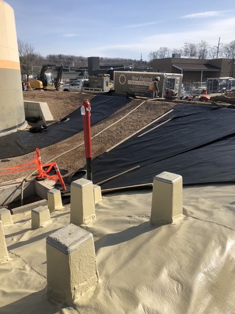 A construction site with a lot of concrete blocks sitting on top of a tarp, being prepared for a protective covering